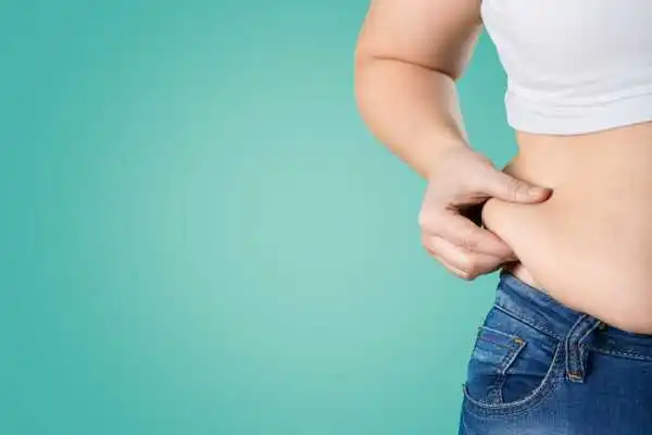 Image of woman pinching her love handles to show weight gain Shettleston